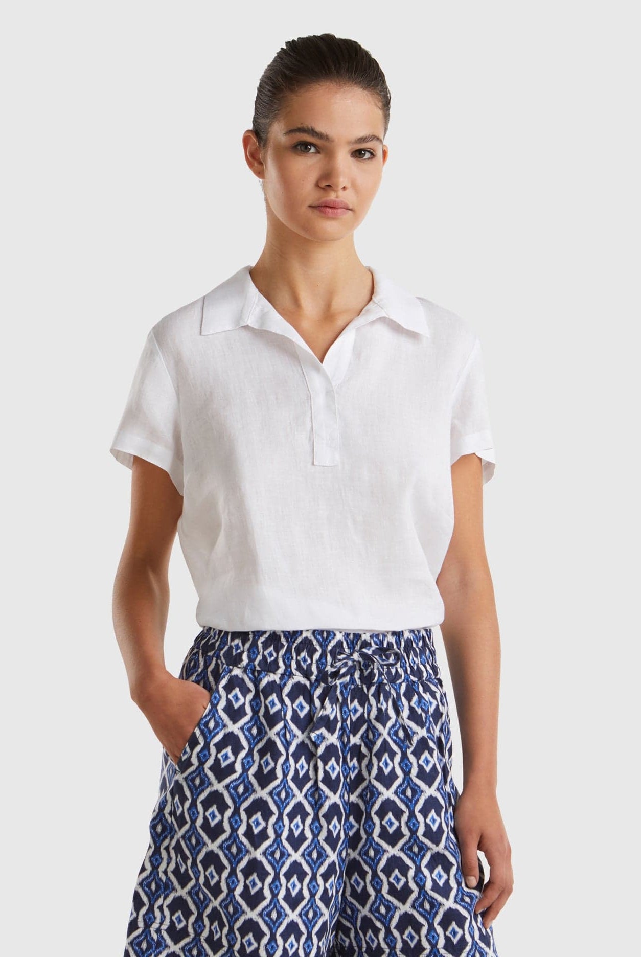 يونايتد كولورز اوف بينيتون بلوزة بولو نسائية بدون أزرار كم قصير من الكتان