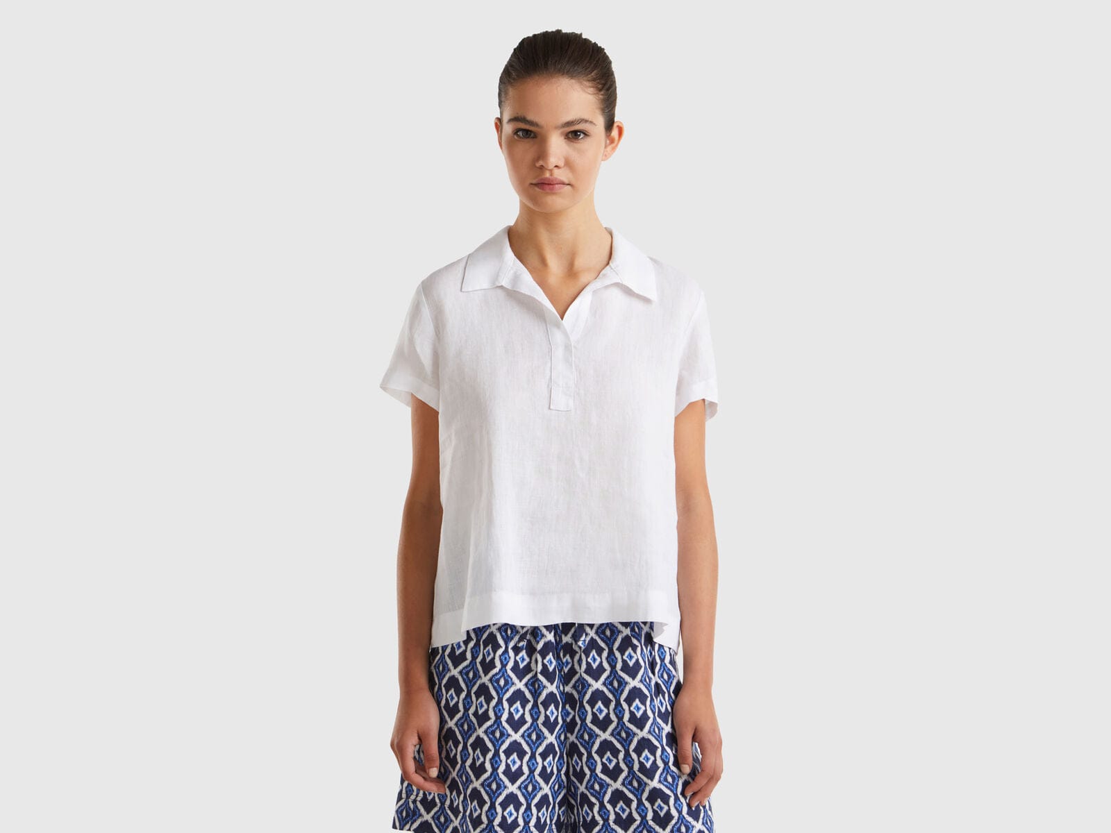 يونايتد كولورز اوف بينيتون بلوزة بولو نسائية بدون أزرار كم قصير من الكتان