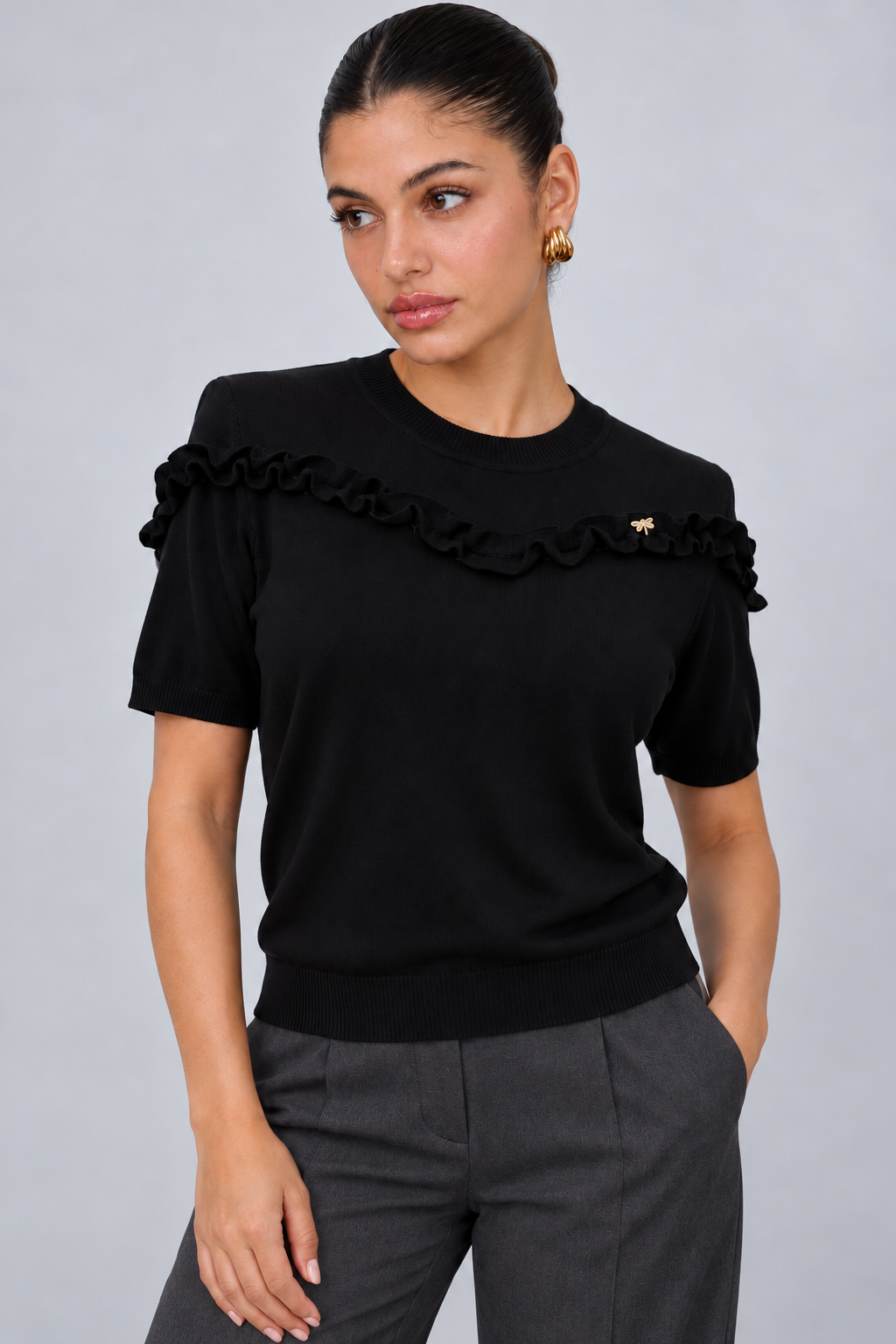 LIV0344AGI black ruffle top detail on model Maria, charcoal trousers
