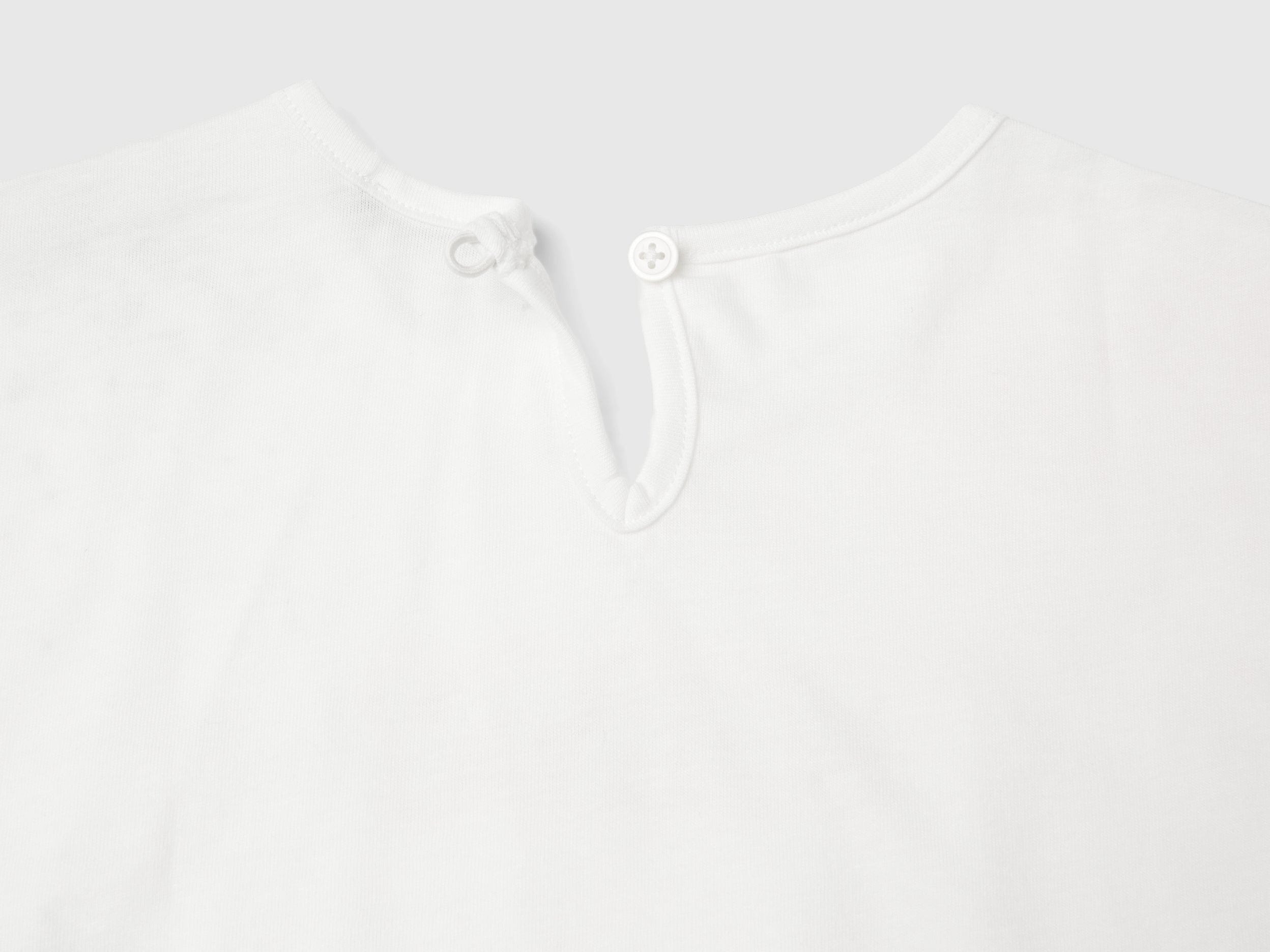 يونايتد كولورز اوف بينيتون تي شيرت بناتي بياقة دائرية كم قصير مع كشكشة في النهاية وطبااعة على الصدر