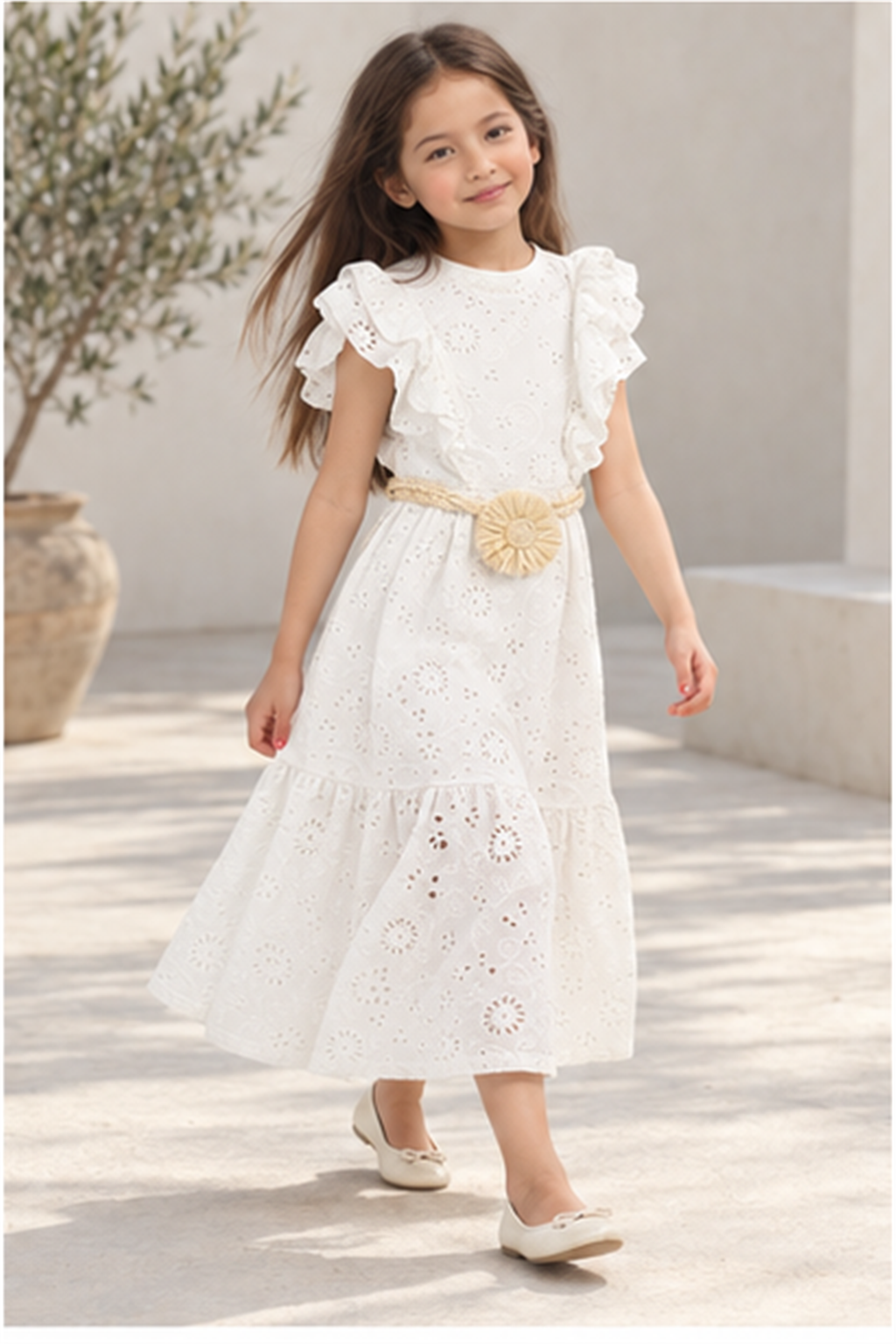 Girls' long white eyelet dress with rosette belt on child model, lifestyle view