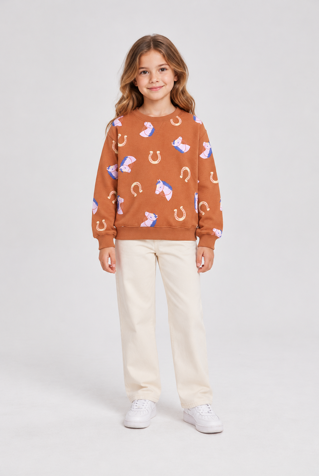 Child model wearing horse-print terracotta sweatshirt, front view