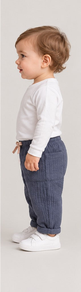 Right side view of boys' slate blue quilted baby trousers on a toddler boy