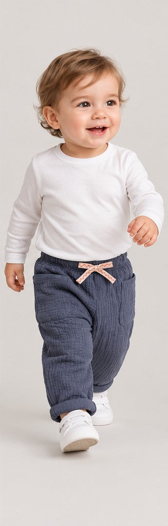 Lifestyle view of boys' slate blue quilted baby trousers on a toddler boy