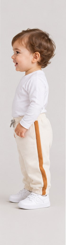 Right side view of boys' ivory baby sweatpants with caramel side stripes on an infant boy