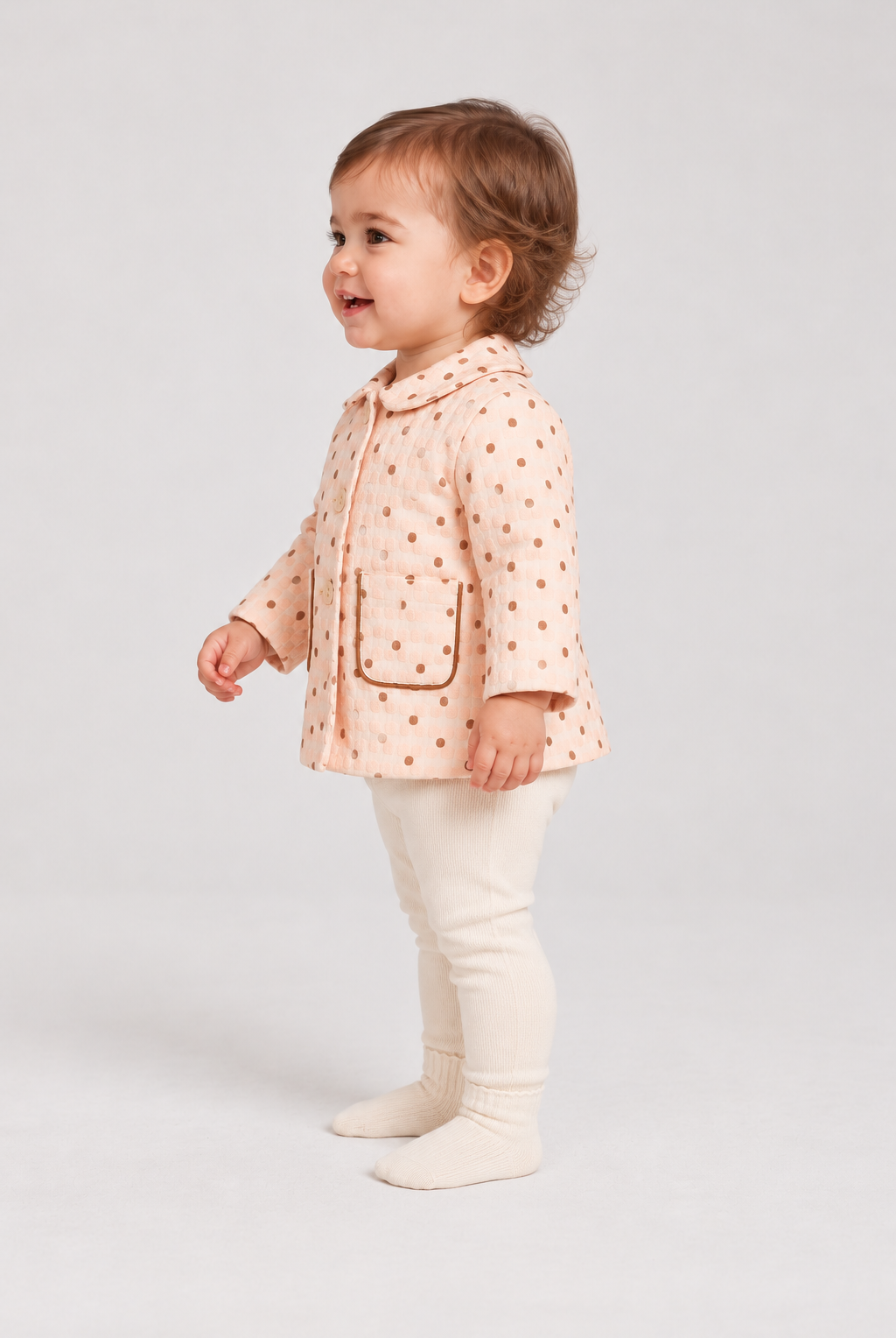 Left side baby girl model view of Gingersnaps dotted jacket