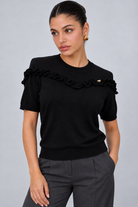 LIV0344AGI black ruffle top detail on model Maria, charcoal trousers