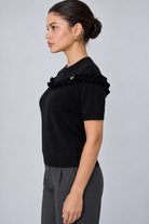LIV0344AGI black ruffle top side on model Maria, charcoal trousers
