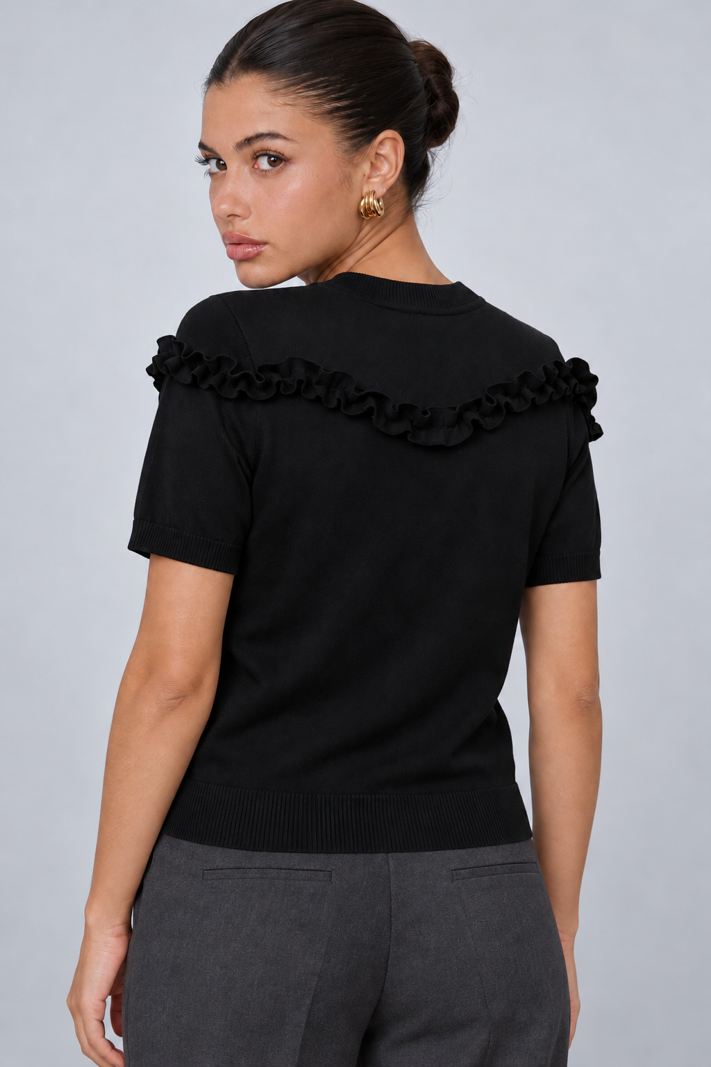 LIV0344AGI black ruffle top back on model Maria, charcoal trousers
