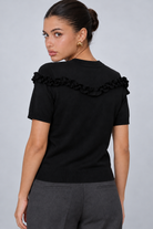 LIV0344AGI black ruffle top back on model Maria, charcoal trousers