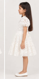 Girl model left view wearing Gingersnaps white embroidered tiered dress