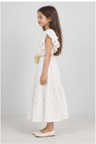 Girls' long white eyelet dress with rosette belt on child model, left side view