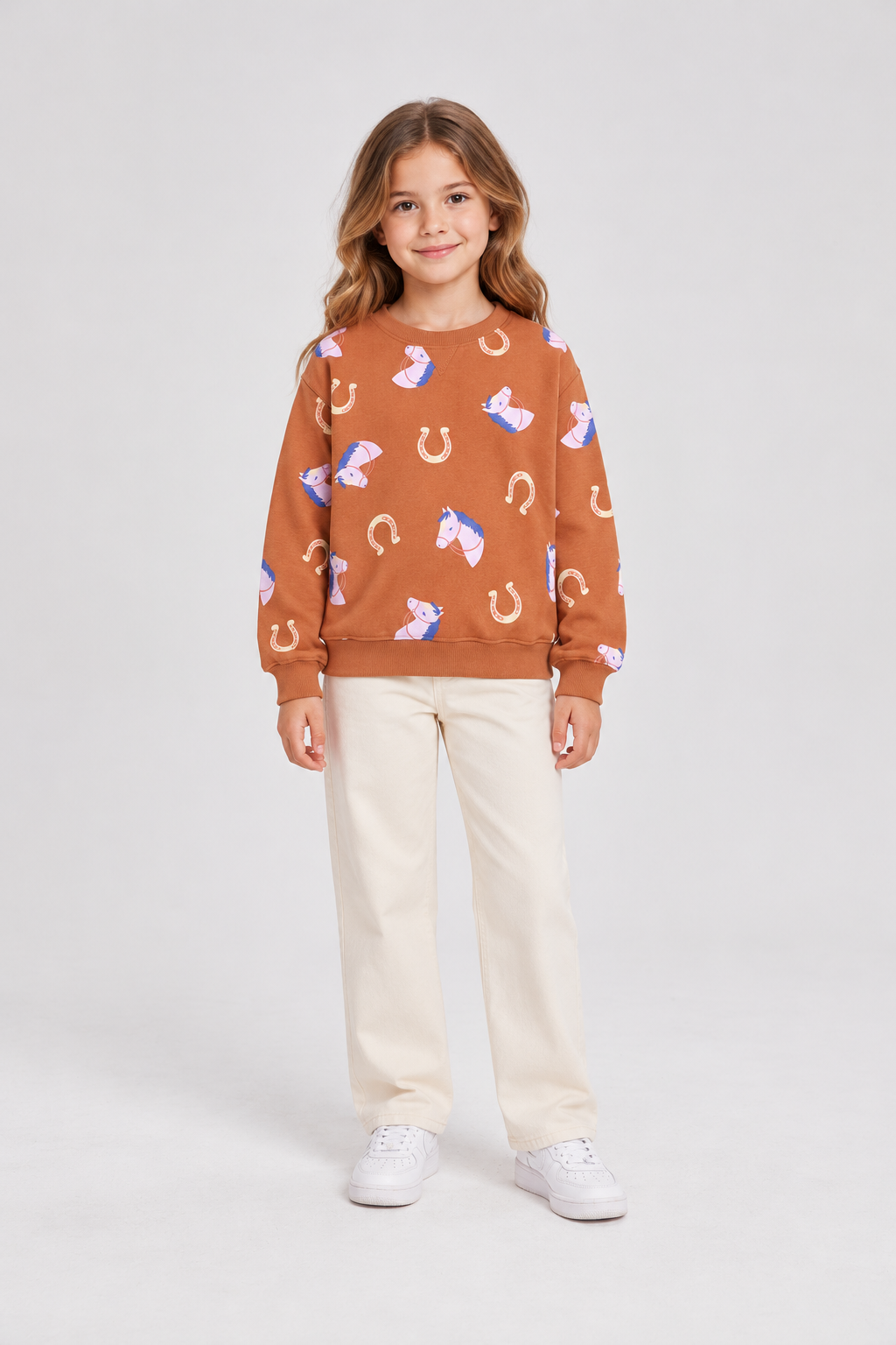 Child model wearing horse-print terracotta sweatshirt, front view