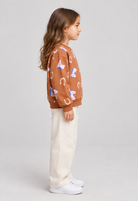 Child model wearing horse-print terracotta sweatshirt, right-side view