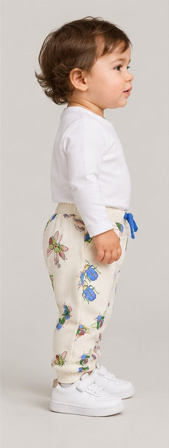Left side view of boys' ivory insect print baby joggers on an infant boy
