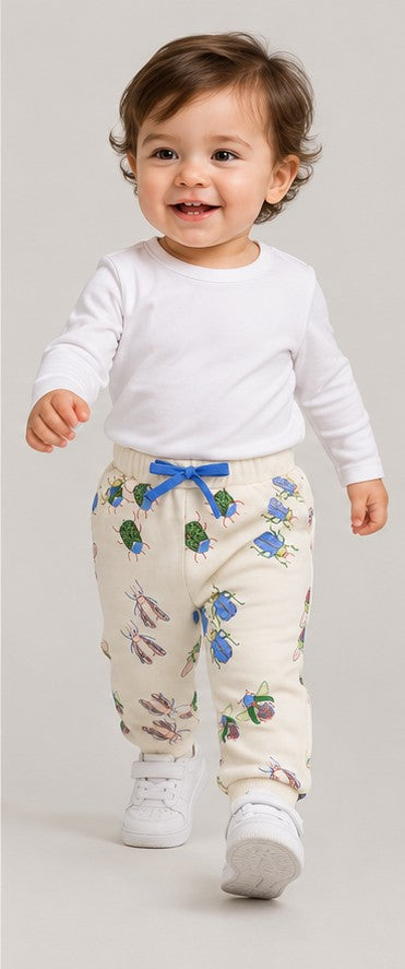 Lifestyle view of boys' ivory insect print baby joggers on an infant boy