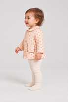 Left side baby girl model view of Gingersnaps dotted jacket