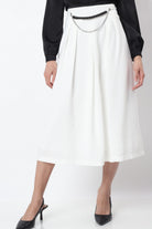 نتشي تنورة ميدي رسمية سادة مزينة بكسرات وسلسال على الخصر من الأمام